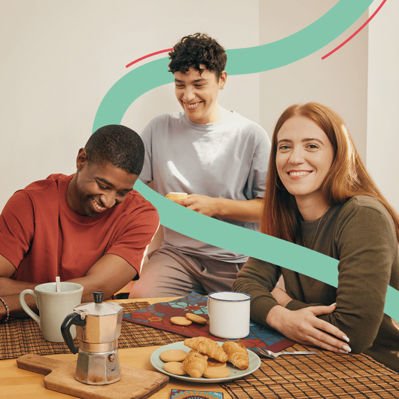 Tre ragazzi seduti sorridono mentre stanno facendo colazione